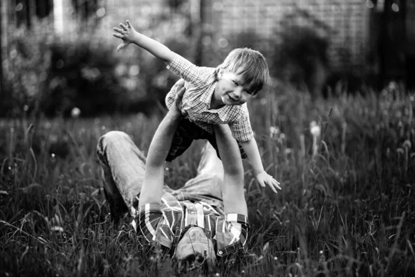 Mannen Håller Sin Unge Son Famnen Och Leker Gräset Svart — Stockfoto