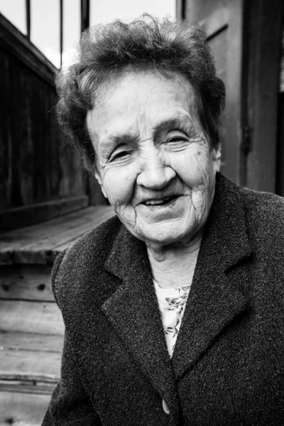 Πορτραίτο Μιας Ηλικιωμένης Γυναίκας Κοντά Ένα Αγροτικό Σπίτι Ασπρόμαυρη Φωτογραφία — Φωτογραφία Αρχείου