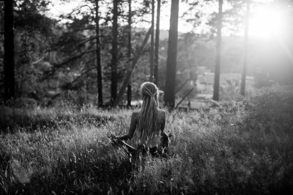 Yoga woman meditating on picturesque glade in forest. Black and white photo.
