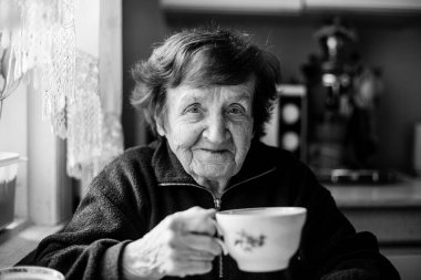 Evinde yaşlı bir kadın. Siyah beyaz fotoğraf.