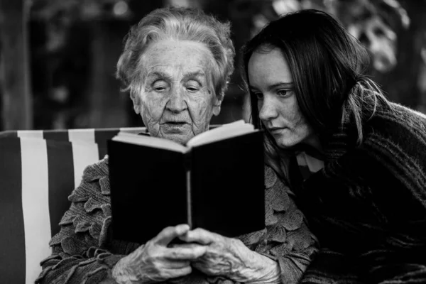Una Anciana Leyendo Libro Sentado Jardín Con Nieta Foto Blanco —  Fotos de Stock
