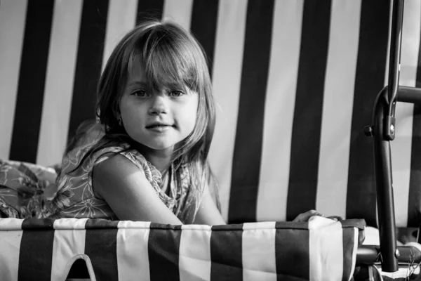 一个小女孩躺在乡村房屋院子里秋千上的画像 黑白照片 — 图库照片
