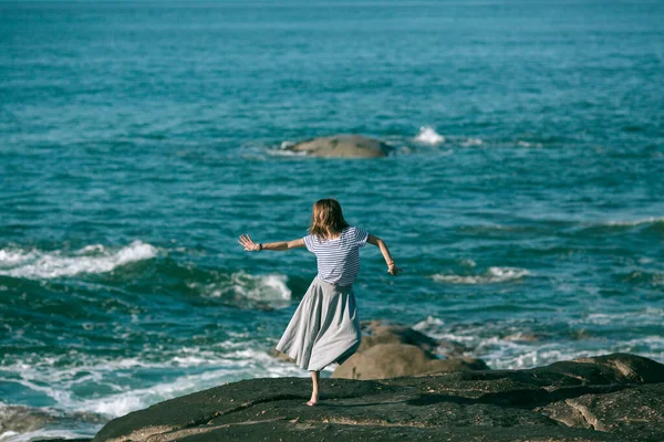 大西洋の岩場で振付をしている若いダンサーの女性 — ストック写真