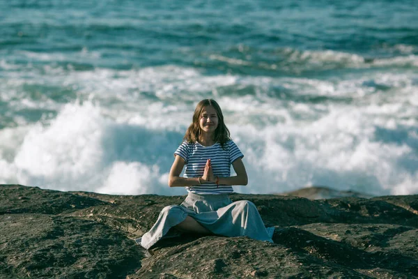漂亮的年轻瑜伽女子坐在海滨的荷花位置上沉思 — 图库照片
