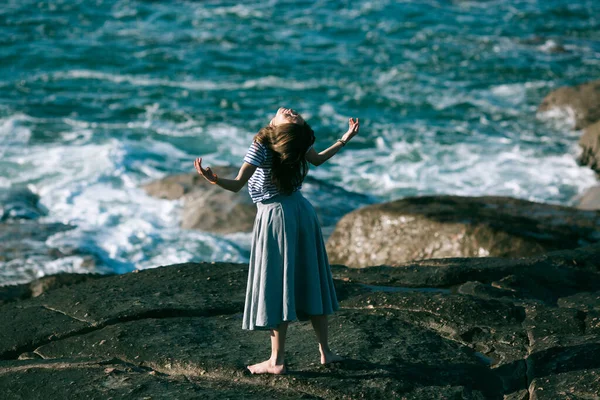 ダンサーの女性は海の岩場で振付に従事しています — ストック写真