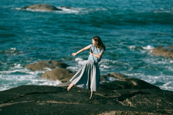 ダンサーの女性は岩だらけの大西洋岸で振付に従事しています — ストック写真
