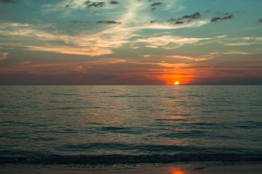Sakin bir okyanusun üzerinde güzel sıcak gün batımı.