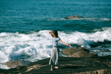 Dansçı kadın kayalık Atlantik sahillerinde koreografiyle meşgul..