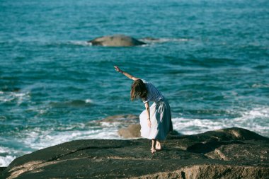 Dansçı kadın Atlantik Okyanusu 'nun kayalık sahillerinde koreografiyle meşgul..