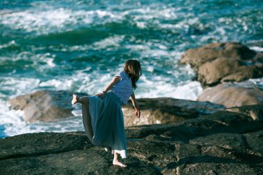 Dansçı bir kadın Atlantik Okyanusu 'nun kayalık sahillerinde koreografiyle meşgul..