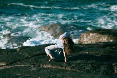 Dansçı bir kadın Atlantik Okyanusu 'nun kayalık sahillerinde koreografiyle meşgul..