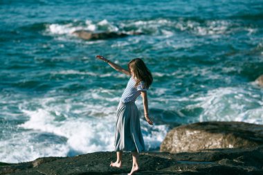 Dansçı bir kadın Atlantik Okyanusu 'nun kayalık sahillerinde koreografiyle meşgul..