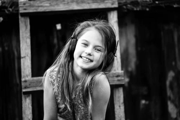 一个女孩在户外欣赏带耳机的音乐 黑白照片 免版税图库图片