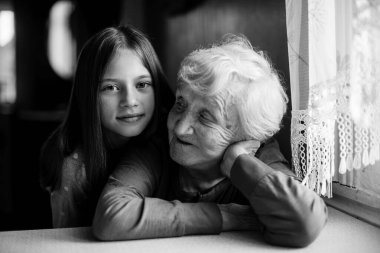 Küçük kız büyükannesine sarılıyor. Siyah beyaz portre.