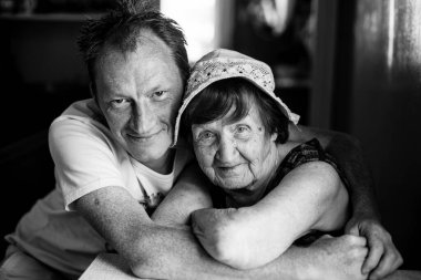 Yetişkin torunuyla yaşlı bir kadının portresi. Siyah beyaz fotoğraf.