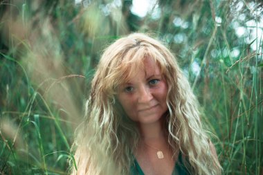 Çayırda açık kahverengi altın saçlı bir kadının portresi..