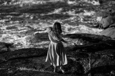 Dans eden kadın Atlantik kıyısında koreografiyle meşgul. Siyah beyaz fotoğraf.