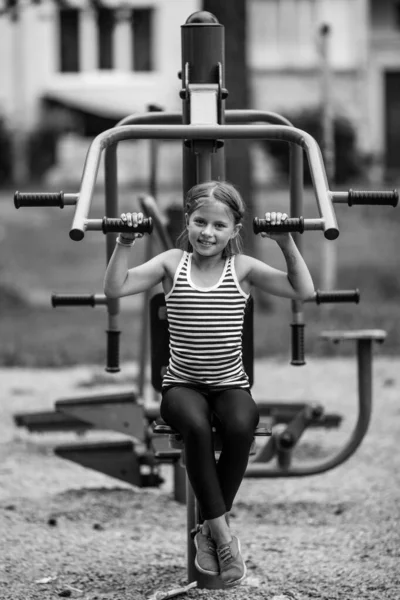 Niña Sentada Una Máquina Entrenamiento Pública Parque Infantil Foto Blanco —  Fotos de Stock