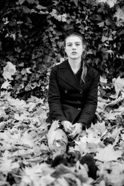 Autumn Park 'ın yaprakları arasında çekici bir kız. Siyah beyaz fotoğraf.