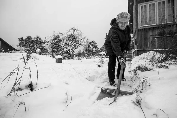 Een Oude Vrouw Reinigt Sneeuw Buurt Van Landelijk Huis Zwart — Stockfoto