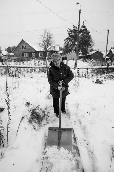 Eine Alte Frau Reinigt Den Schnee Der Nähe Ihres Bauernhauses — Stockfoto