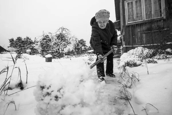 Stará Žena Uklízí Sníh Poblíž Svého Venkovského Domu Vesnici Černobílá — Stock fotografie