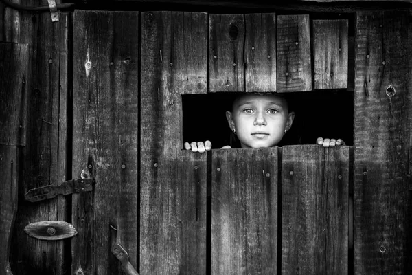 Una Bambina Sbircia Ansiosamente Attraverso Una Crepa Nella Porta Chiusa — Foto Stock