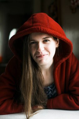 Kırmızılı uzun saçlı genç kadın, evin içinde portre..