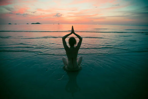 夕日のビーチのヨガの女性のシルエット 健康的なライフスタイルに関する抽象的な写真 — ストック写真