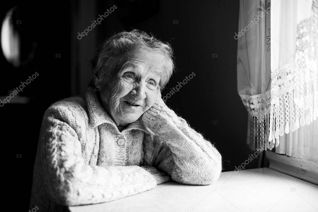 Portrait of an old woman. Black and white contrast photo.