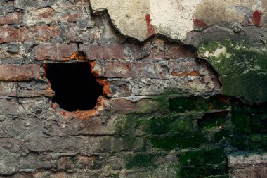 Terk edilmiş bir ev. Kırık alçılı eski tuğla duvar dokusu.