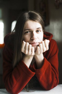 Kırmızılı, uzun saçlı, evde portresi olan genç bir kadın.. 