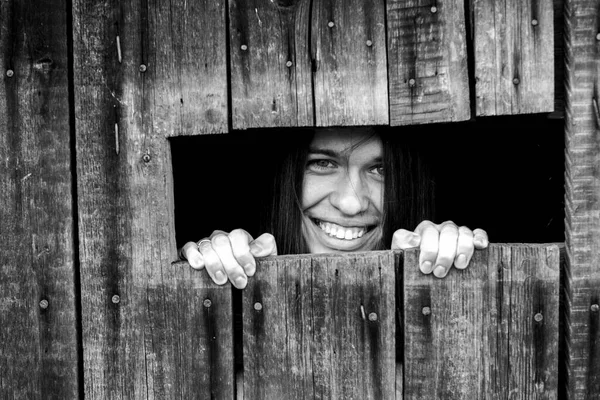 小さな窓から若い女性が目を通している 白黒写真 — ストック写真
