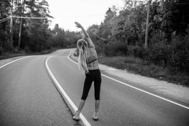 Yolda bir kadın ısınıyor. Siyah beyaz fotoğraf.