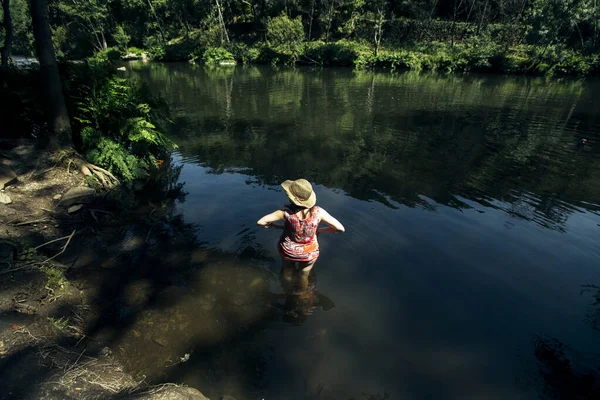 山岳地帯の森の川の水の中に腰を下ろしている女性 — ストック写真