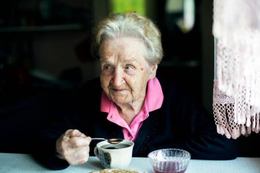 Çay içen yaşlı bir kadının portresi. 