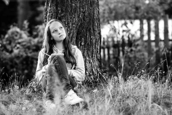 Adolescente Escrevendo Caderno Sentado Parque Foto Preto Branco — Fotografia de Stock