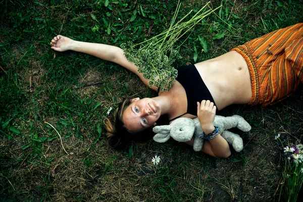 Çocuk Oyuncağı Olan Bir Genç Kız Yeşil Çimlerin Üzerinde Uzanır — Stok fotoğraf