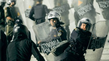 ATİNA, GREECE - 15 Nisan 2015: Protestocu solcu ve anarşist grupların işgal ettiği Atina Üniversitesi önünde düzenlenen bir protesto sırasında çevik kuvvet ve protestocular.