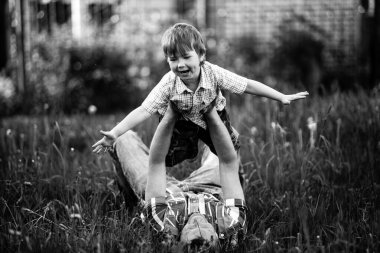 Baba ve küçük oğlu parkta mutlu. Siyah beyaz fotoğraf.