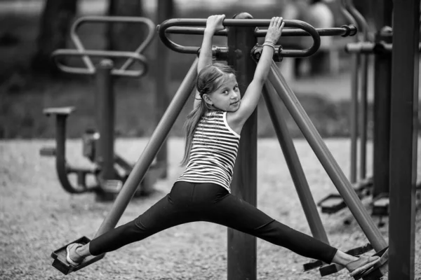 Kleines Mädchen Auf Einem Trainer Gerät Auf Dem Spielplatz Schwarz — Stockfoto