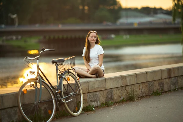 Una Adolescente Con Una Bicicleta Terraplén Del Río Atardecer —  Fotos de Stock