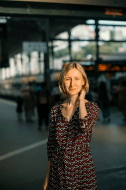 Tren istasyonunda bir kadın duruyor..