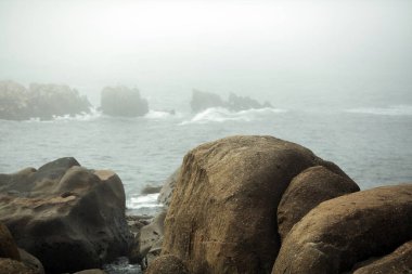 Vila Nova de Gaia kıyısındaki kayalar sisli havada, Porto, Portekiz.