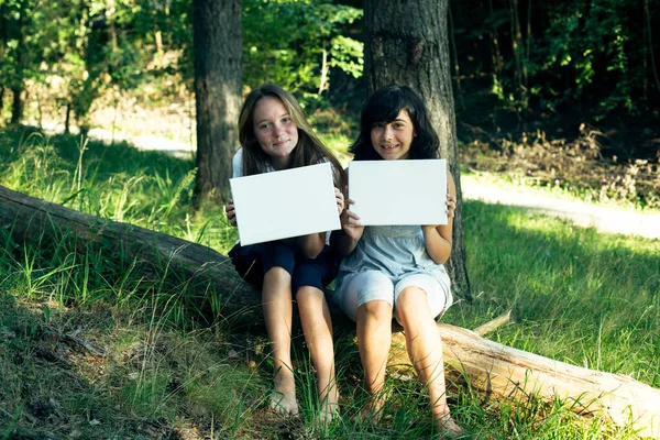 Две Девочки Подростка Держащие Чистый Белый Лист Бумаги Баннер Вашего — стоковое фото
