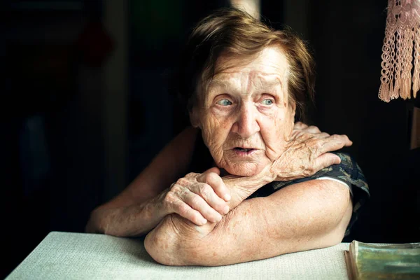 Μια Ηλικιωμένη Γυναίκα Κάθεται Στο Τραπέζι Στο Σπίτι — Φωτογραφία Αρχείου