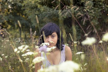 bir çayır oturan genç kız.