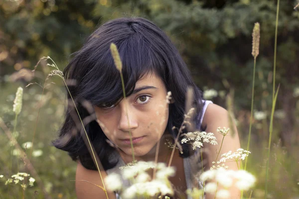 Jeune fille assise dans une prairie . — Photo