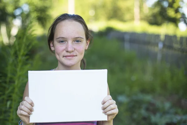 Menina segurando papel branco — Fotografia de Stock