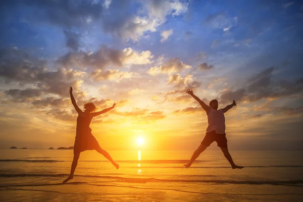Couple jumping on beach — Stock Photo, Image